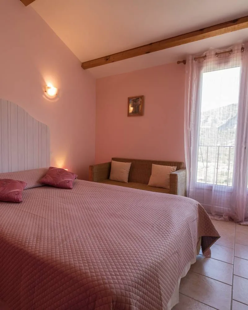 Chambre confort : grand lit, canapé et fenêtre sur la montagne